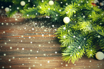 Obraz na płótnie Canvas Christmas fir tree branches with lights on wooden table