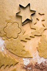 Cookies forms and gingerbread dough on wooden pastry board