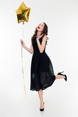 Beautiful happy woman laughing and holding golden star shaped balloon