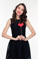 Attractive smiling woman in retro style standing with heart props