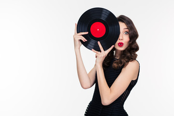 Playful beautiful woman covered half of face with vinyl disc