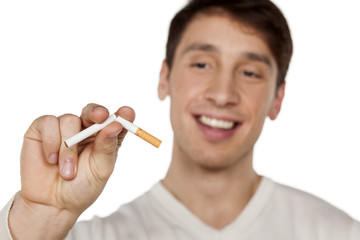 smiling young man holding a broken cigarette