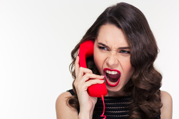 Angry woman in retro style screaming and talking on telephone