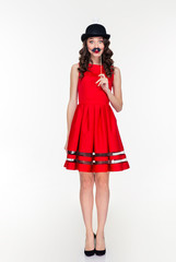 Comical woman in hat with light bulb holding fake moustache