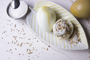 Teeeier mit geröstetem Sesam und Joghurt-Dip auf einer Schale