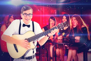 Composite image of geeky hipster playing guitar and singing