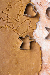 Cookies forms and gingerbread dough on wooden pastry board