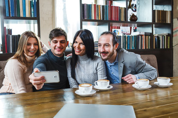 Group of friends with coffee and looking at smartphone