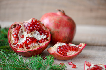 Pomegranate with festive decorations over wooden background