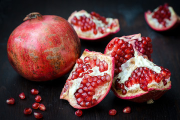 Pomegranate with festive decorations over wooden background