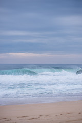 Fototapeta na wymiar Wave crashing on a coast in Nazare