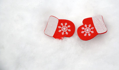 Wooden christmas mittens decoration on snow background.