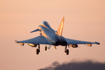 Fighter jet landing at sunset