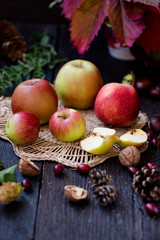 Fresh apples with autumn leaves on wooden table