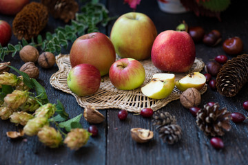 Naklejka na ściany i meble Fresh apples with autumn leaves on wooden table