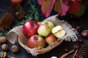 Fresh apples with autumn leaves on wooden table