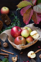 Fresh apples with autumn leaves on wooden table