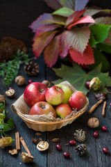 Fresh apples with autumn leaves on wooden table