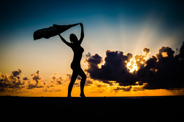 Frau im Sonnenuntergang am Strand