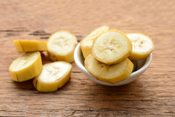 sliced banana in a cup over a table.