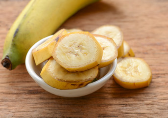 sliced banana in a cup over a table.