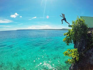 Man jumping from cliffside on holiday in Philippines