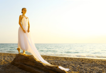 Fototapeta na wymiar ballet dancer resting on the coast at sunset