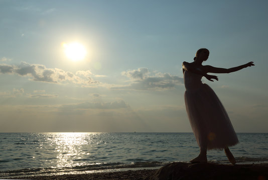 dancing ballerina  at sunset on the coast