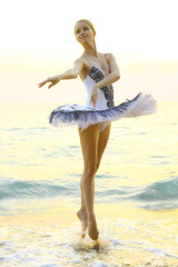 Fototapeta na wymiar ballerina dancing on the coast at sunset