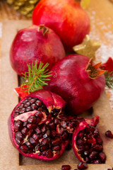 Obraz na płótnie Canvas Fresh ripe pomegranates on wooden background and Christmas decoration.
