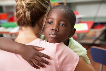 Teacher and boy hugging 