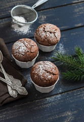 Chocolate muffins,  Christmas tree and Christmas decorations on dark wooden surface