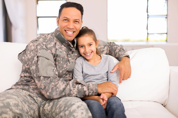 military father sitting on the couch with his daughter