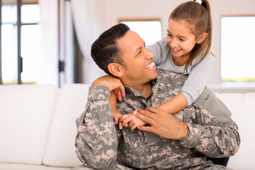 little girl hugging her military father - 98254091