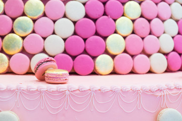 Two pink gold macarons on the pink cake