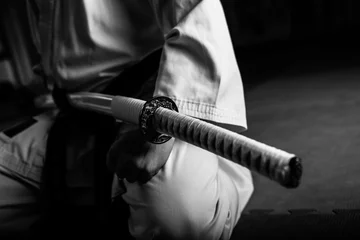 Papier Peint photo Lavable Arts martiaux Close up of young martial arts fighter with katana siting in seiza position, black and white.