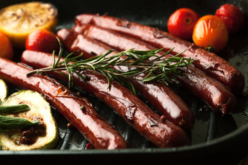 Grill sausages with vegetables, rosemary and spices