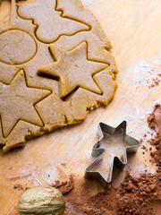 Cookies forms and gingerbread dough on wooden pastry board