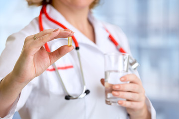 Doctor woman showing pill in hand