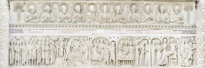 sculptures from marble on the bas above the door of cathedral in Pisa in Italy