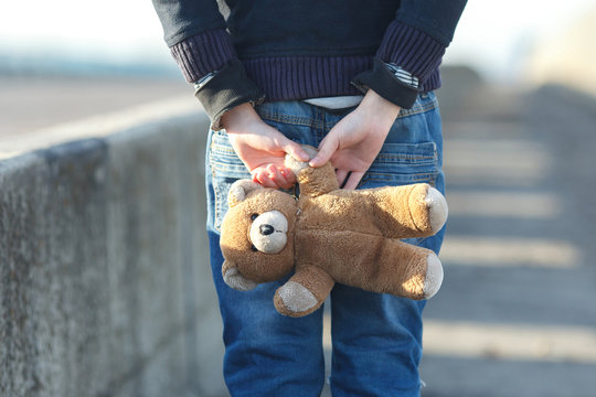 Little Homeless Boy Holding A Teddy Bear