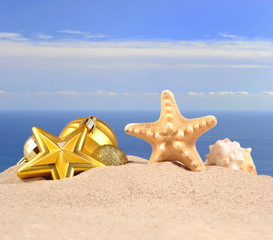 Fototapeta na wymiar Christmas decorations, seashells and starfish on a beach sand