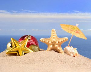 Fototapeta na wymiar Christmas decorations, seashells and starfish on a beach sand