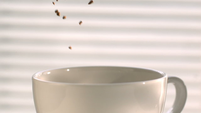 Coffee Pouring into a White Cup in Slow Motion, Instant Coffee Falling into a Cup in High Speed Motion