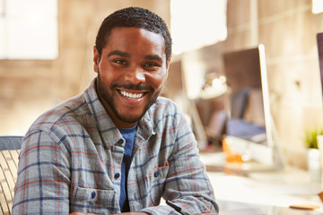 Portrait Of Male Designer Working At Desk In Modern Office