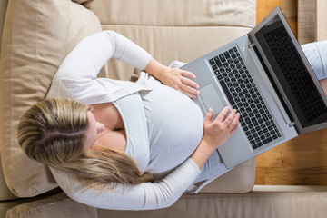 pregnant woman spends time a laptop