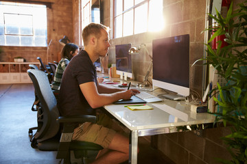 Designers Working At Desks In Modern Office