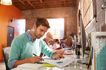 Team Of Designers Working At Desks In Modern Office