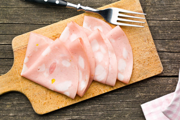 Slices of Sausage Mortadella on cutting board - obrazy, fototapety, plakaty