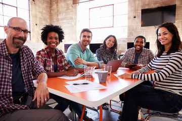 Group Of Designers Having Meeting Around Table In Office